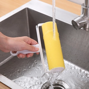 Abwaschbare gelbe Fusselrolle mit ergonomischem Griff unter fließendem Wasser gereinigt