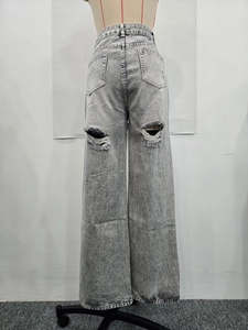 Détail du jean gris délavé à taille haute avec grandes déchirures à l'arrière des jambes