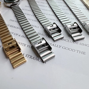 Close-up of link chain watch bands in gold and silver steel with folding clasps