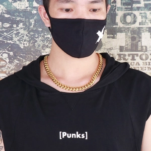 Detailed view of a man wearing a thick golden stainless steel Cuban chain necklace