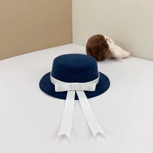 Detailed view of mini navy blue felt hat with white ribbon and bow for 20cm plush dolls
