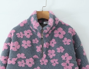 Detail of grey fleece pullover with pink floral pattern and quarter-zip collar closure