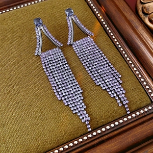 Macro shot of purple rhinestone fringe earrings with geometric triangle metal framework