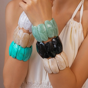 Detail of colorful marbled acrylic chunky bracelets showing natural resin textures
