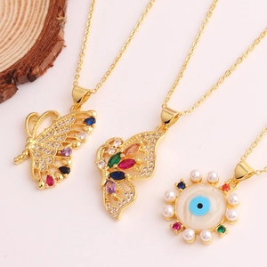 Detail of gold butterfly and evil eye necklaces with colorful zircons and pearls