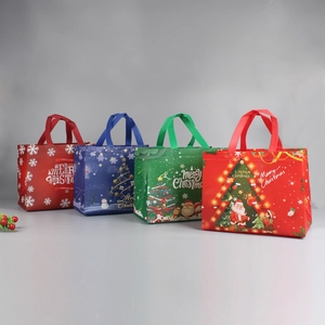 Detailed view of four colorful non-woven Christmas gift bags with festive patterns