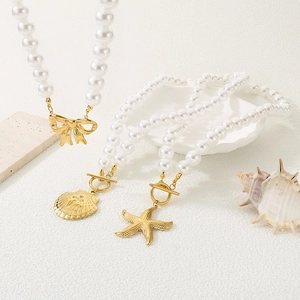 Detailed view of pearl necklaces featuring gold bow, shell, and starfish pendants