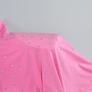 Detail of pink dress shoulder featuring silver rhinestones and premium fabric texture