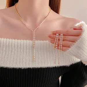 Close-up of elegant zircon water drop tassel necklace and long earrings set on a model