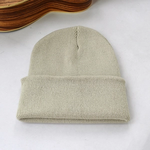 Gros plan d'un bonnet en maille beige montrant la texture fine et le revers double épaisseur