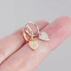 Macro detail of S925 silver heart hoop earrings with gold and silver zircon inlay