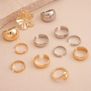 Three-piece gold and silver geometric rings set featuring minimalist flower and wide bands