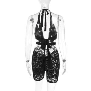 Close-up of the intricate floral lace texture and backless detail of the black romper