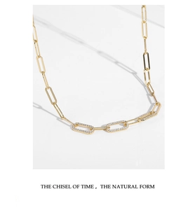 Detail of gold link necklace featuring three rectangle links set with small diamonds