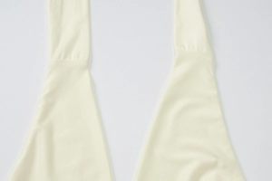 Close-up of the beige knitted halter neckline and mesh fabric texture of the slim dress