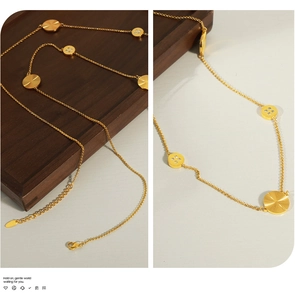 Macro detail of gold-plated titanium pendant necklace with sunburst engraving and zircons
