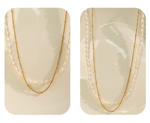 Detail of elegant double-layer gold chain necklace with baroque freshwater pearls