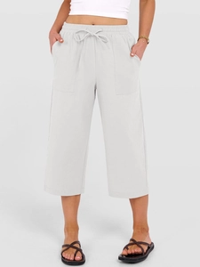 Dettaglio della vita con coulisse e ampie tasche laterali su pantaloni in lino grigio chiaro