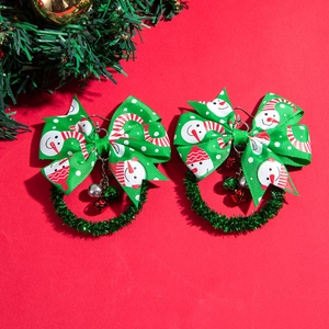 Detail of Christmas wreath earrings with snowman pattern and small metal bells decoration