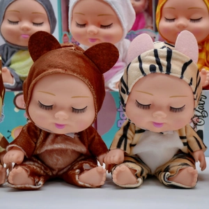 Close-up of 8-inch BJD sleeping baby dolls in plush brown bear and yellow tiger outfits