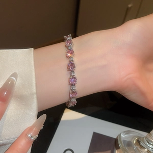 Close-up of elegant tennis bracelet featuring pink round zircons and baguette-cut stones