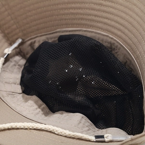 Detail of breathable mesh lining and adjustable windproof drawstring on khaki sun hat