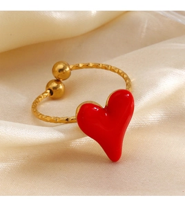 Macro detail of red enamel heart on adjustable gold-plated stainless steel ring