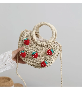 Nahaufnahme der Strohtasche mit roten Häkel-Erdbeeren und Kordelzug-Futter für den Sommer
