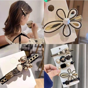 Elegant gold hair clip set featuring bear and pearl charms with a stylish fabric flower