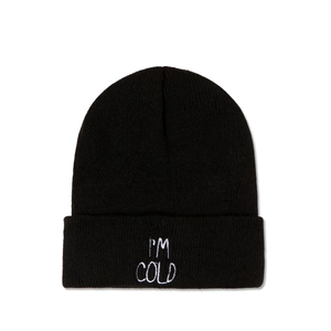 Close-up of I'M COLD white embroidery on a black ribbed knit beanie hat folded cuff