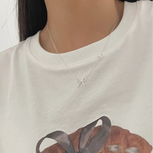 Exquisite 925 sterling silver double bow pendant necklace worn on a woman's collarbone