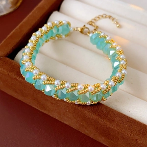 Close-up of mint green crystal and pearl beaded bracelet in a jewelry display box