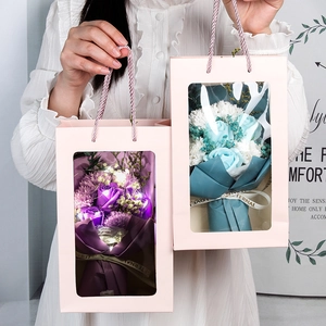 Detail of soap flower gift box with LED lights and roses in a pink portable paper bag