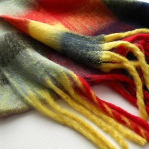 Detailed close-up of rainbow plaid tassel scarf with soft brushed cashmere feel texture