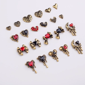 Flat lay of vintage gold alloy nail charms including hearts, bows, and rhinestones