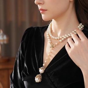 Elegant multi-layer pearl necklace with golden bird pendant and vintage pearl charms