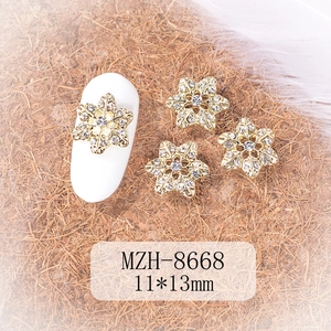 Macro shot of 11x13mm gold snowflake nail charms with sparkling rhinestones for DIY
