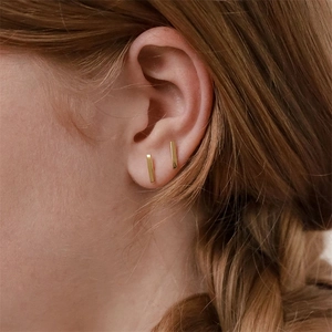 Minimalist gold bar earrings in stainless steel on model side profile for a modern look