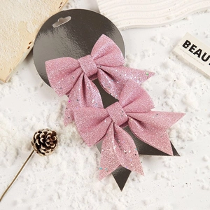 Nahaufnahme von rosa Glitzer-Weihnachtsschleifen auf Displaykarte mit Winterdekoration