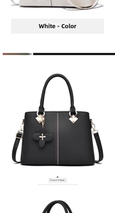 Detail view of lychee pattern leather handbag with clover charm and rhinestones