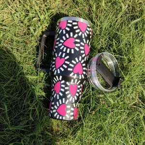 Top view of 40oz stainless steel heart tumbler with handle on green grass