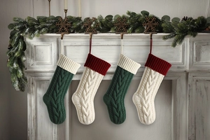 Close-up of four knitted cable pattern Christmas stockings hanging on a festive mantel