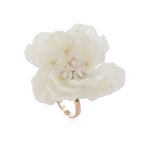 Macro shot of white handmade petal ring with silver glitter and gold crystal center