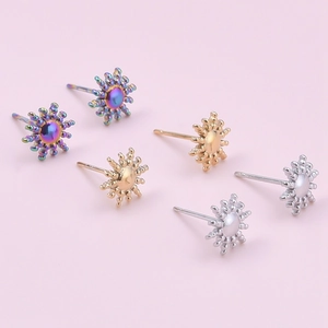 Detailed view of sunburst stud earrings in iridescent, gold, and silver stainless steel