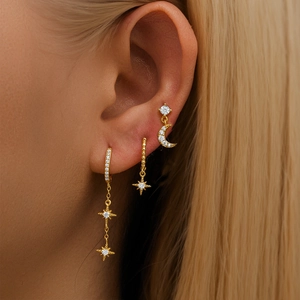 Close-up of three-piece gold star and moon tassel earring set with cubic zirconia