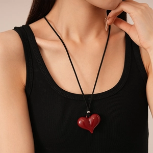 Close-up of red resin 3D heart pendant necklace worn on neck with black cord