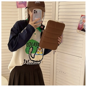 Brown quilted laptop sleeve with cat embroidery shown in a lifestyle mirror selfie