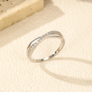 Minimalist S925 sterling silver criss-cross ring with small diamonds on beige background