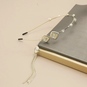 Detailed view of golden rhinestone butterfly headband with pearls on books