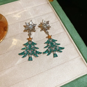 Detail of Christmas tree earrings with green zircon and pearls on velvet box